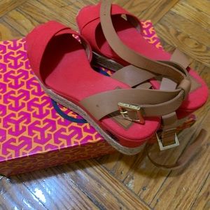 Red open toed wedge with brown straps around the ankles.